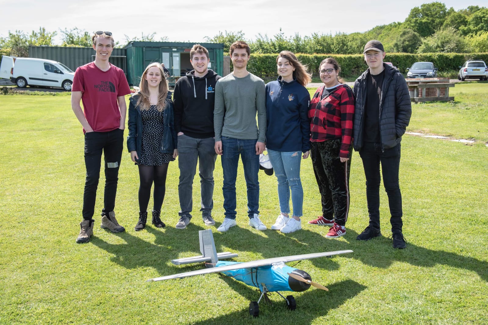 Photo of group of aero students posing with the scale airplane they created